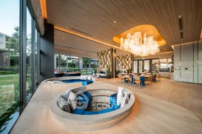 Luxurious modern living room with unique sunken seating and elegant chandelier, offering a spacious and stylish ambiance.