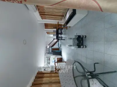 Spacious living room with modern furniture and tiled flooring in a bright, airy home.