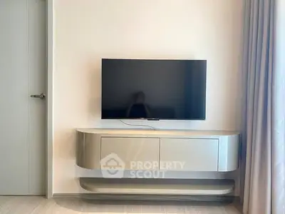 Modern living room with sleek TV stand and mounted flat-screen TV, minimalist design.