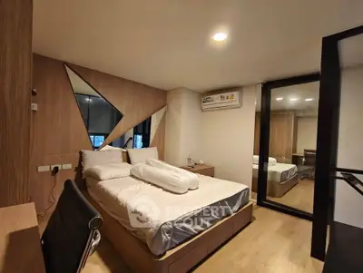 Modern bedroom with stylish decor and mirrored wardrobe in a cozy apartment.