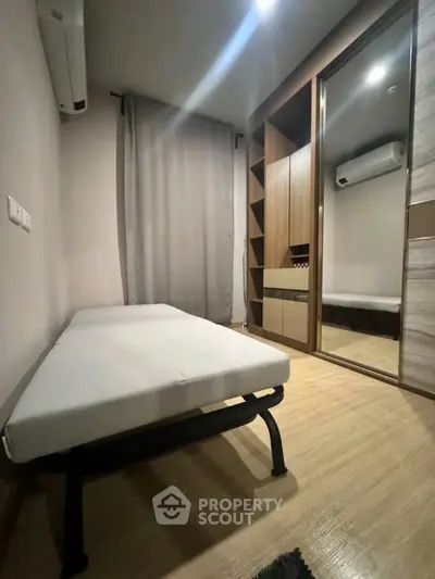 Cozy bedroom with modern furnishings and mirrored wardrobe in a stylish apartment.