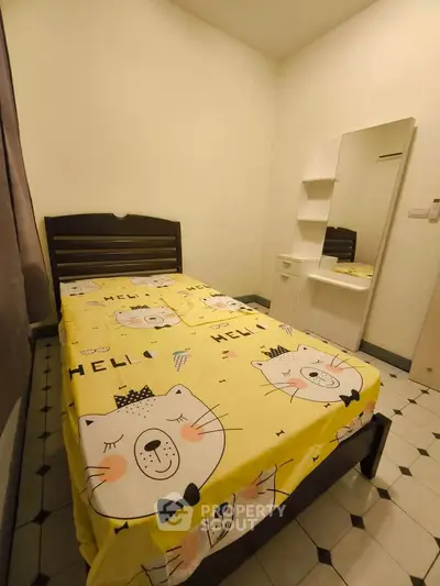 Cozy bedroom with charming cat-themed bedding and a sleek vanity mirror.