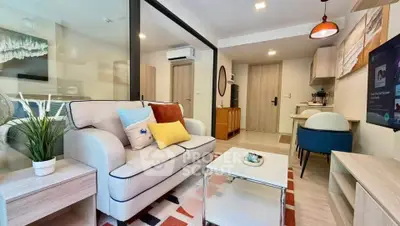 Modern living room with stylish decor and open layout, featuring cozy seating and vibrant accents.