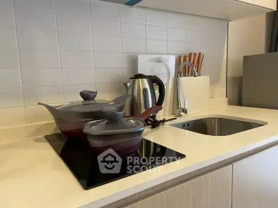 Modern kitchen with sleek induction cooktop and stylish cookware, perfect for culinary enthusiasts.