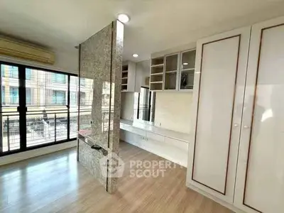 Spacious modern living room with large windows and stylish partition in urban apartment.
