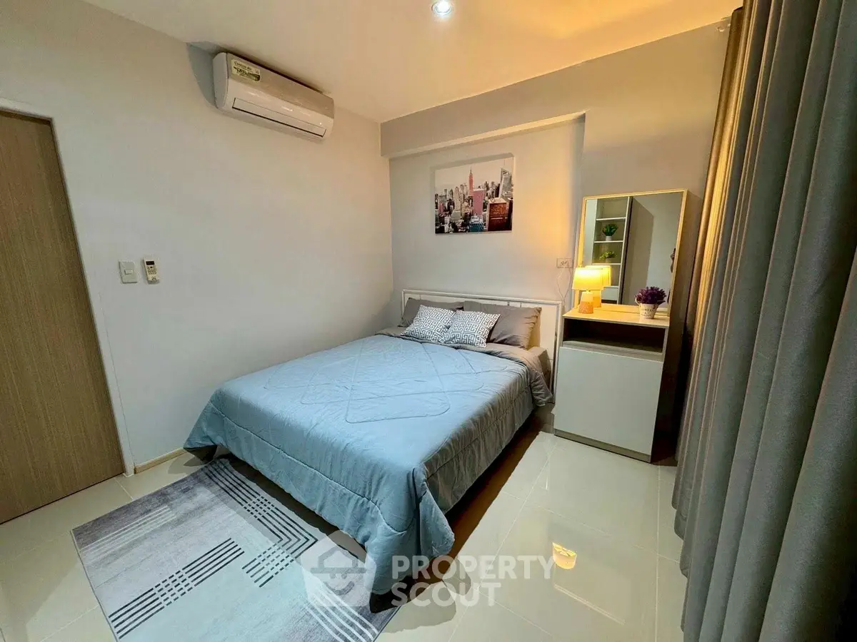 Cozy bedroom with modern decor and air conditioning, featuring a stylish bed and elegant lighting.