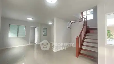 Spacious modern living room with elegant staircase and natural light