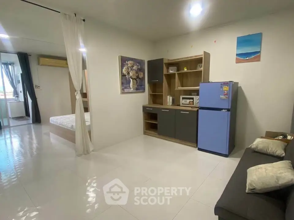 Modern studio apartment with open layout, featuring a compact kitchen and cozy living area.