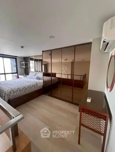 Modern bedroom with mirrored wardrobe and stylish decor in a contemporary apartment.