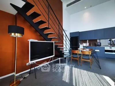 Modern open-plan living room with stylish staircase and sleek kitchen design