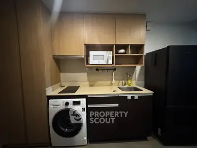 Modern kitchen with sleek appliances and ample storage in a stylish apartment.
