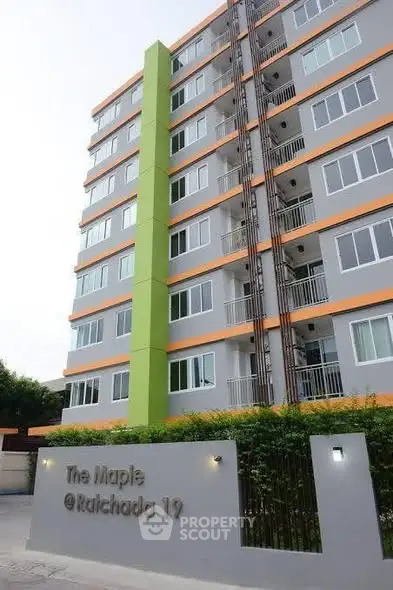 Modern apartment building exterior with vibrant green accent and sleek design at The Maple Ratchada 19.