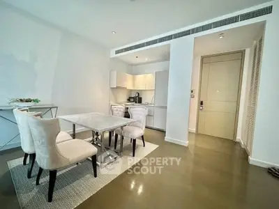 Modern dining area with elegant chairs and sleek kitchen in luxury apartment.
