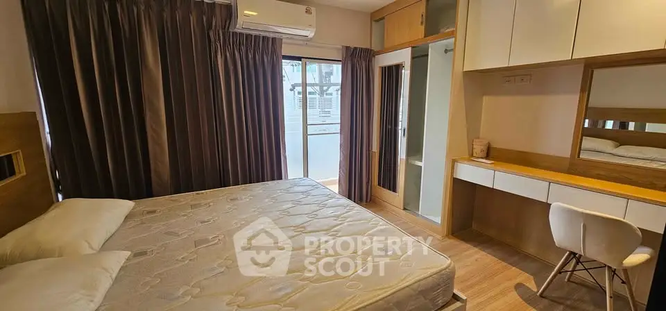 Spacious bedroom with balcony access and modern furnishings