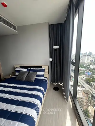 Modern bedroom with large window offering stunning city views