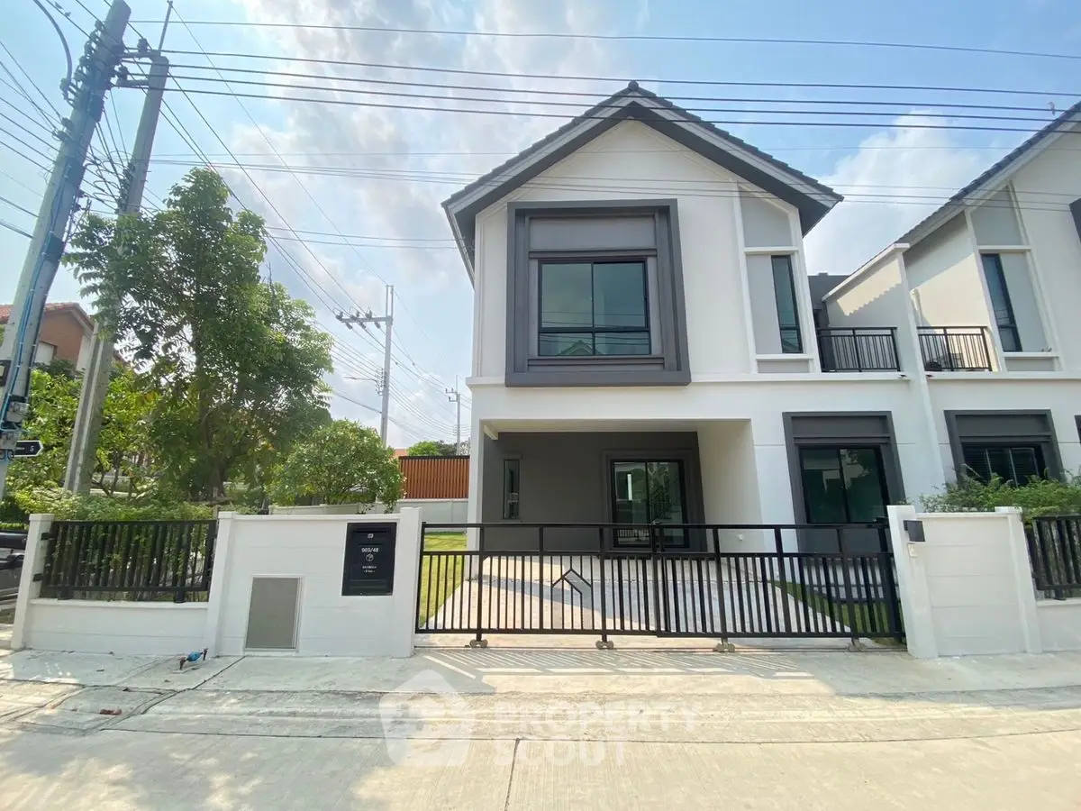 Modern two-story house with sleek design and spacious front yard, perfect for family living.