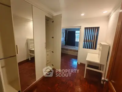 Spacious bedroom with wooden flooring and built-in wardrobe, perfect for modern living.