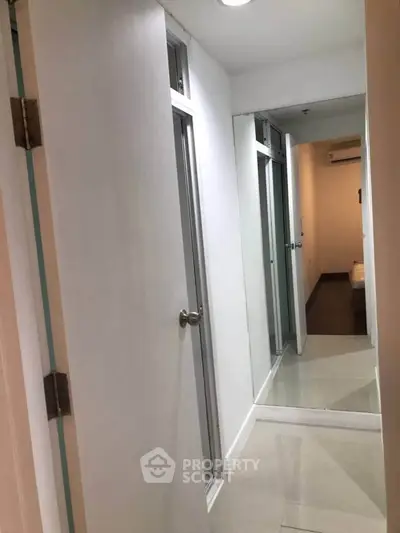 Modern apartment hallway with sleek doors and glossy tiled flooring.