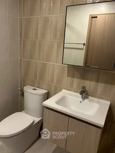 Modern bathroom with sleek fixtures and neutral tile design, perfect for a contemporary home.