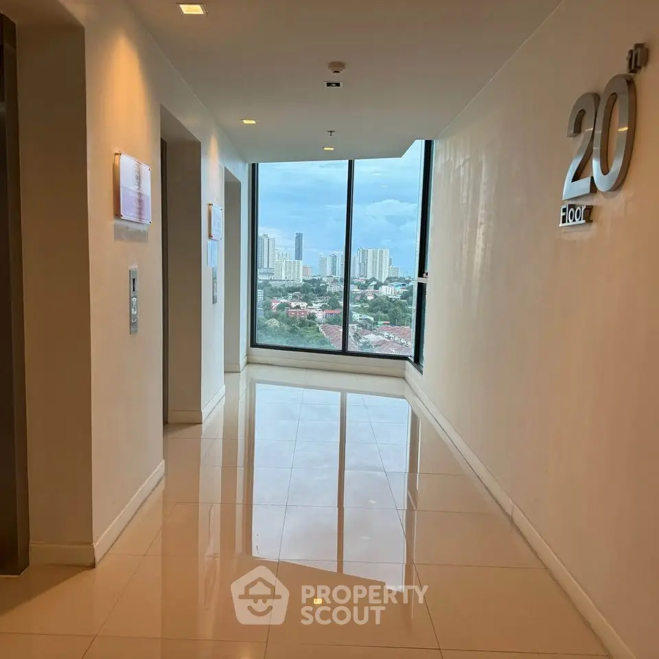 Modern high-rise building hallway with city view from the 20th floor.