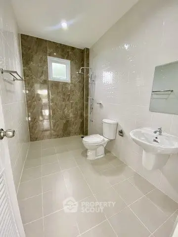Spacious modern bathroom with elegant tile design and sleek fixtures.