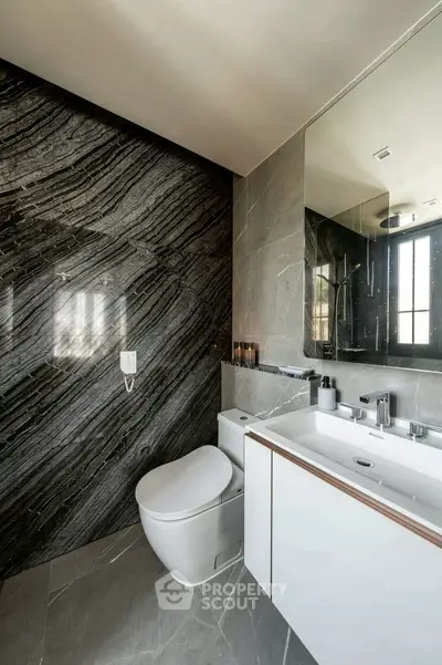 Luxurious modern bathroom with sleek marble walls and contemporary fixtures.