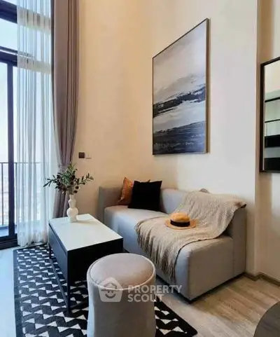 Stylish modern living room with high ceilings and large windows, featuring cozy sofa and chic decor.