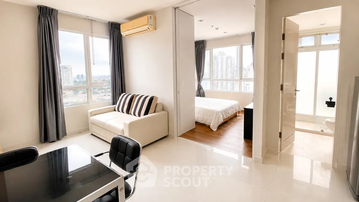 Modern apartment interior with living room, bedroom, and city view, featuring sleek furniture and natural light.