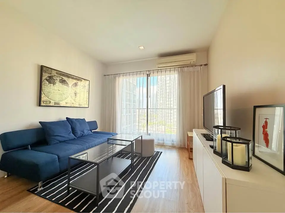 Modern living room with stylish decor and city view, featuring a sleek sofa and entertainment center.