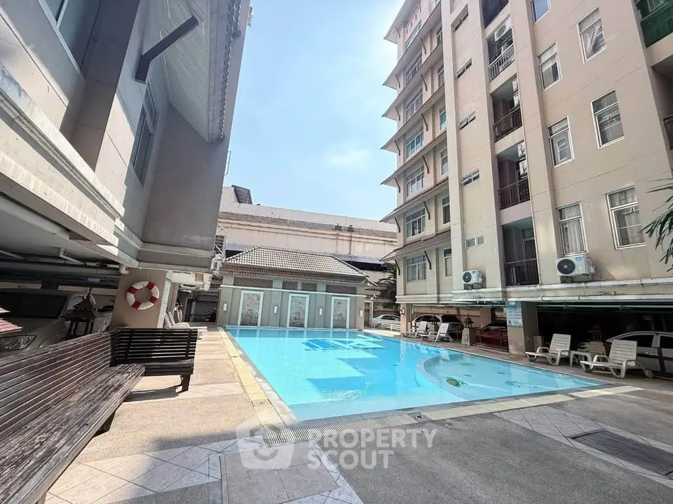 Spacious apartment complex with inviting outdoor pool and sun loungers.