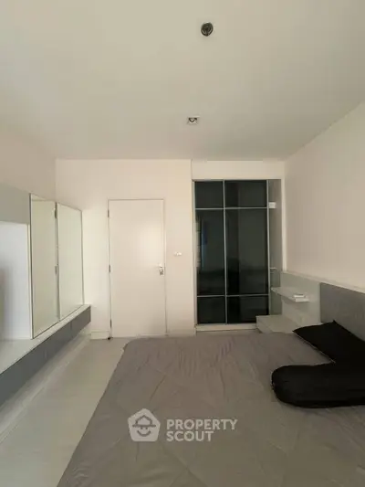 Modern minimalist bedroom with sleek built-in wardrobe and neutral tones.