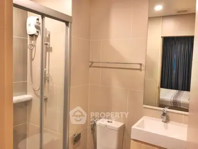 Modern bathroom with glass shower and sleek fixtures in cozy apartment.