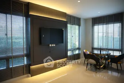 Modern living room with sleek blinds and wall-mounted TV, featuring a stylish dining area.