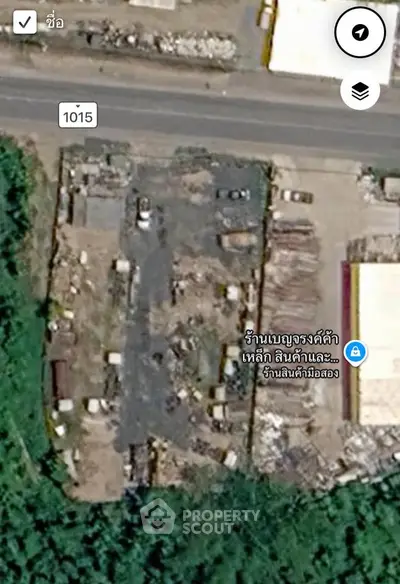 Aerial view of industrial property with storage and surrounding greenery.