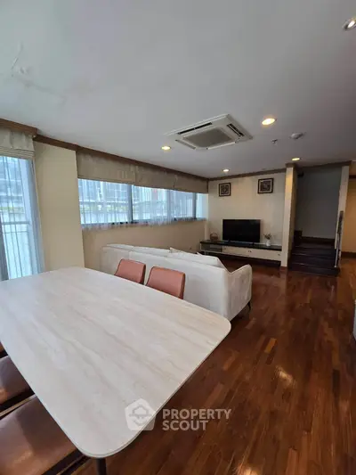 Spacious living room with elegant wooden flooring and modern furniture in a luxury apartment.