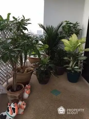 Charming balcony with lush potted plants and city view, perfect for relaxation.