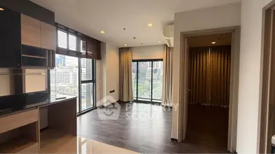 Modern apartment with open layout and city view, featuring sleek kitchen and spacious living area.
