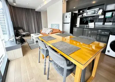 Modern open-plan living room and kitchen with sleek design and natural light.