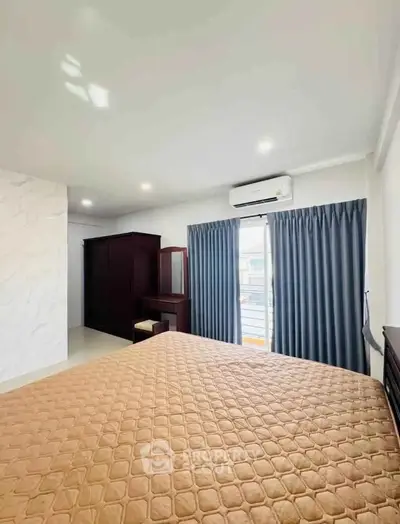 Spacious bedroom with modern decor and large window for natural light.
