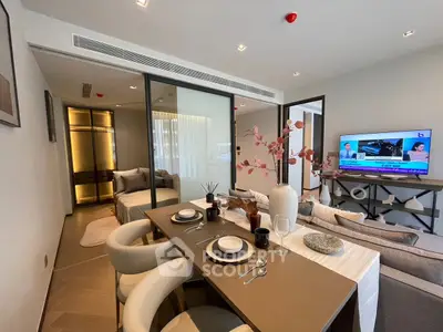 Modern open-plan living and dining area with stylish decor and TV setup