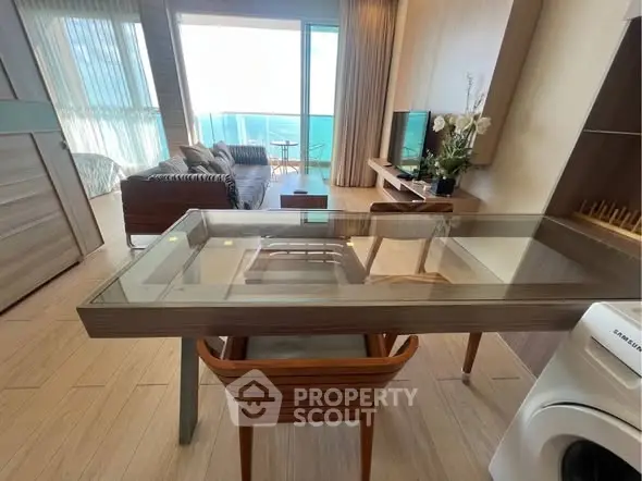 Modern living room with ocean view, stylish furniture, and integrated washing machine in open layout.