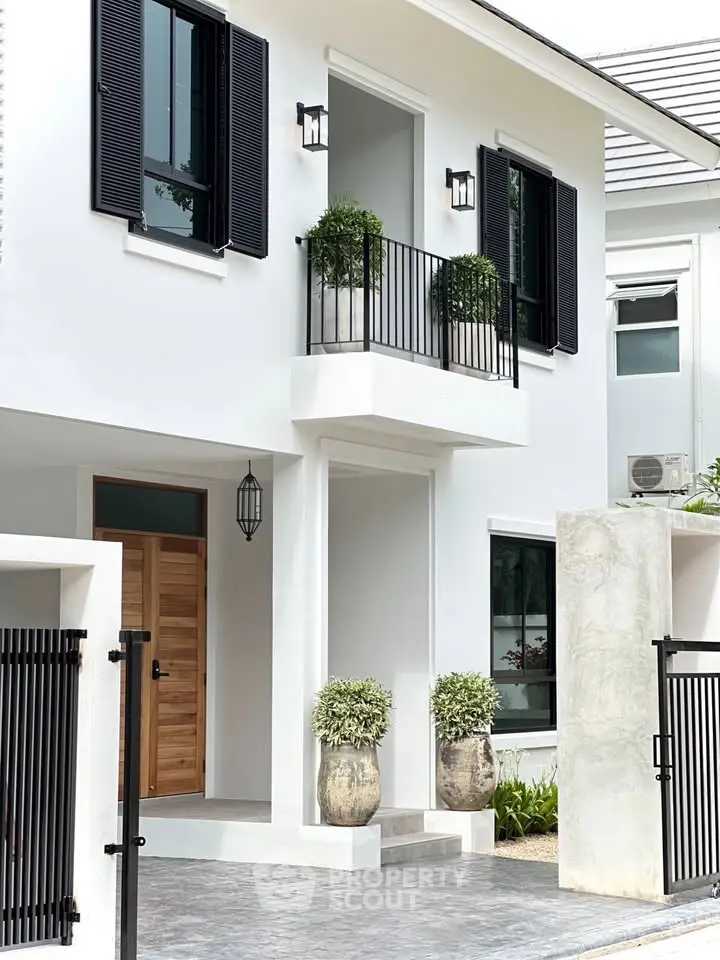 Elegant modern house exterior with stylish balcony and lush greenery