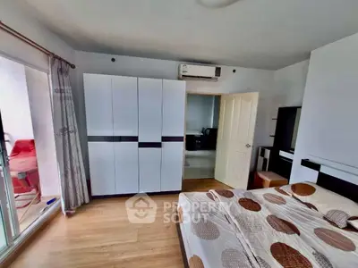Spacious bedroom with modern wardrobe and balcony access