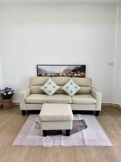 Stylish living room with modern beige sofa and decorative cushions, perfect for cozy relaxation.
