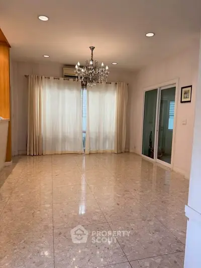 Spacious living room with elegant chandelier and marble flooring