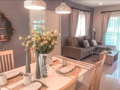 Charming open-plan living and dining area with cozy decor and natural light.