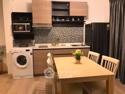 Modern kitchen with dining area, featuring wooden cabinets, washing machine, and stylish backsplash.