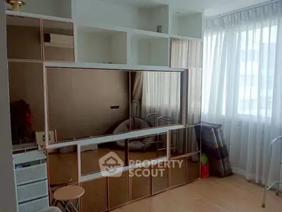 Spacious living room with large windows and modern shelving unit