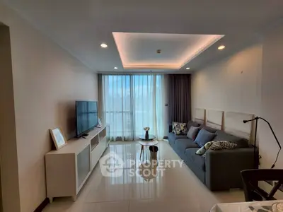Modern living room with sleek design and large windows offering natural light.