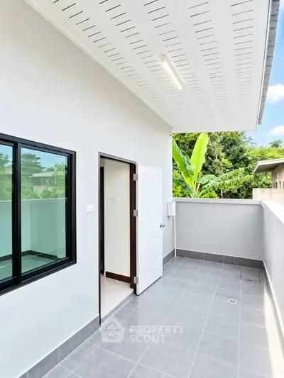 Modern balcony with sleek design and lush greenery view, perfect for relaxation and outdoor enjoyment.